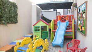 A children's play area with a slide, climbing structures, and a small house. - Hotel Penny (Rimini)