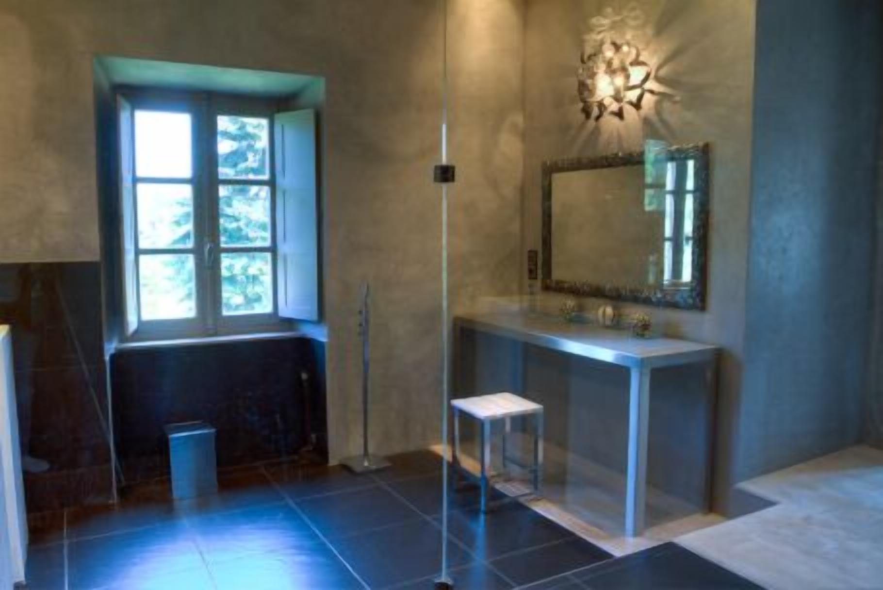 Un baño con un amplio ventanal, un espejo y un lavamanos moderno.