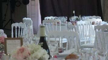 A table set for a formal event with white chairs and clear glassware.