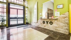 A reception area with a stone wall, a reception desk, and a sign that reads "OYO." - Parque Empresarial by Vivere Stays (Aviles)