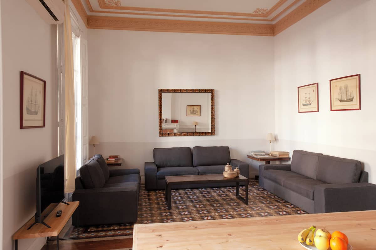 A living room with two sofas, a coffee table, a TV, and framed pictures on the walls.