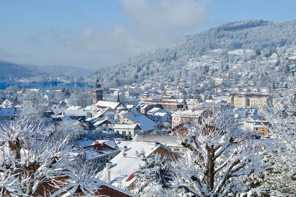 A snow-covered town with buildings and a prominent church tower.