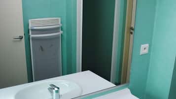 A bathroom with two white sinks, a mirror, and a door leading to another room.