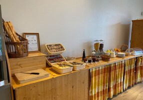 Disposição de buffet com diversos alimentos e utensílios.
