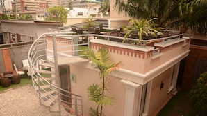 A rooftop terrace with a spiral staircase, outdoor seating, and potted plants. - Fryburg Suites (Lagos)