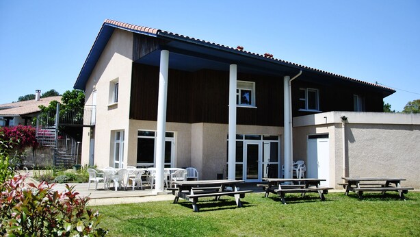 A two-story building with a flat roof, large windows, and a covered patio area with outdoor seating. - Le Relais de Port d'Albret - Hostel (Vieux-Boucau-les-Bains)
