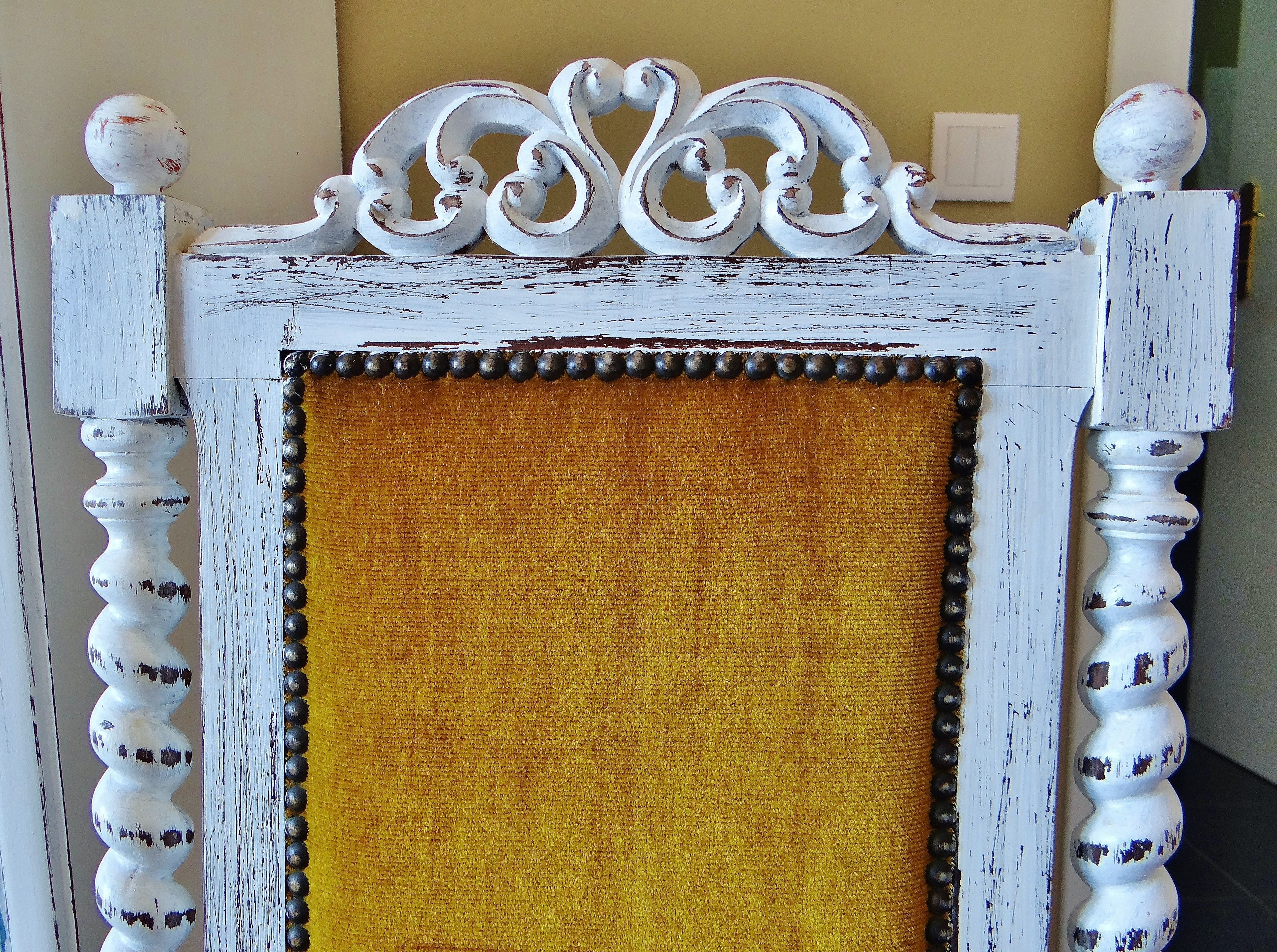 Un marco blanco ornamentado con un panel amarillo texturizado.