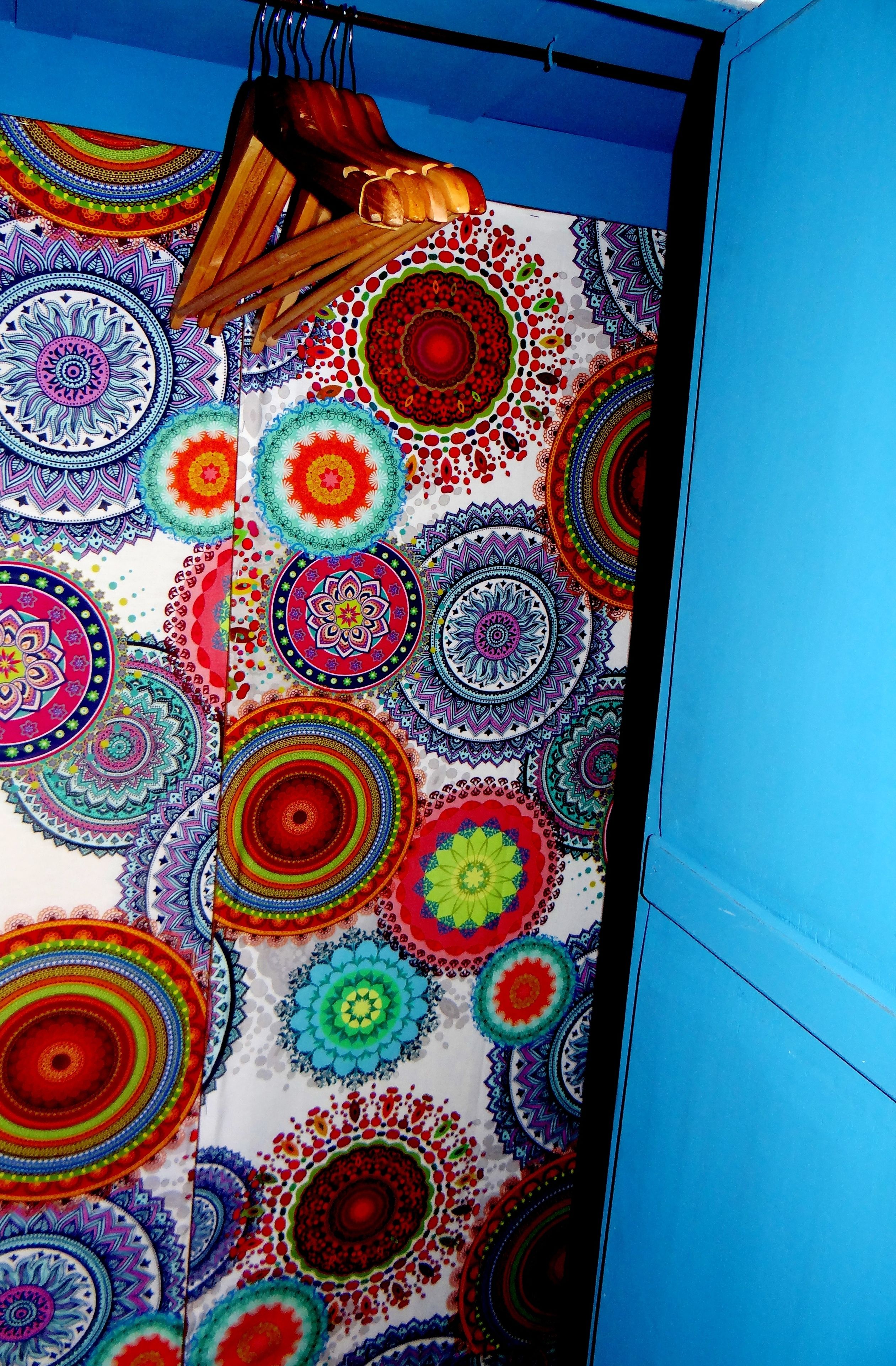 A room with a vibrant, circular patterned wall and a blue door.