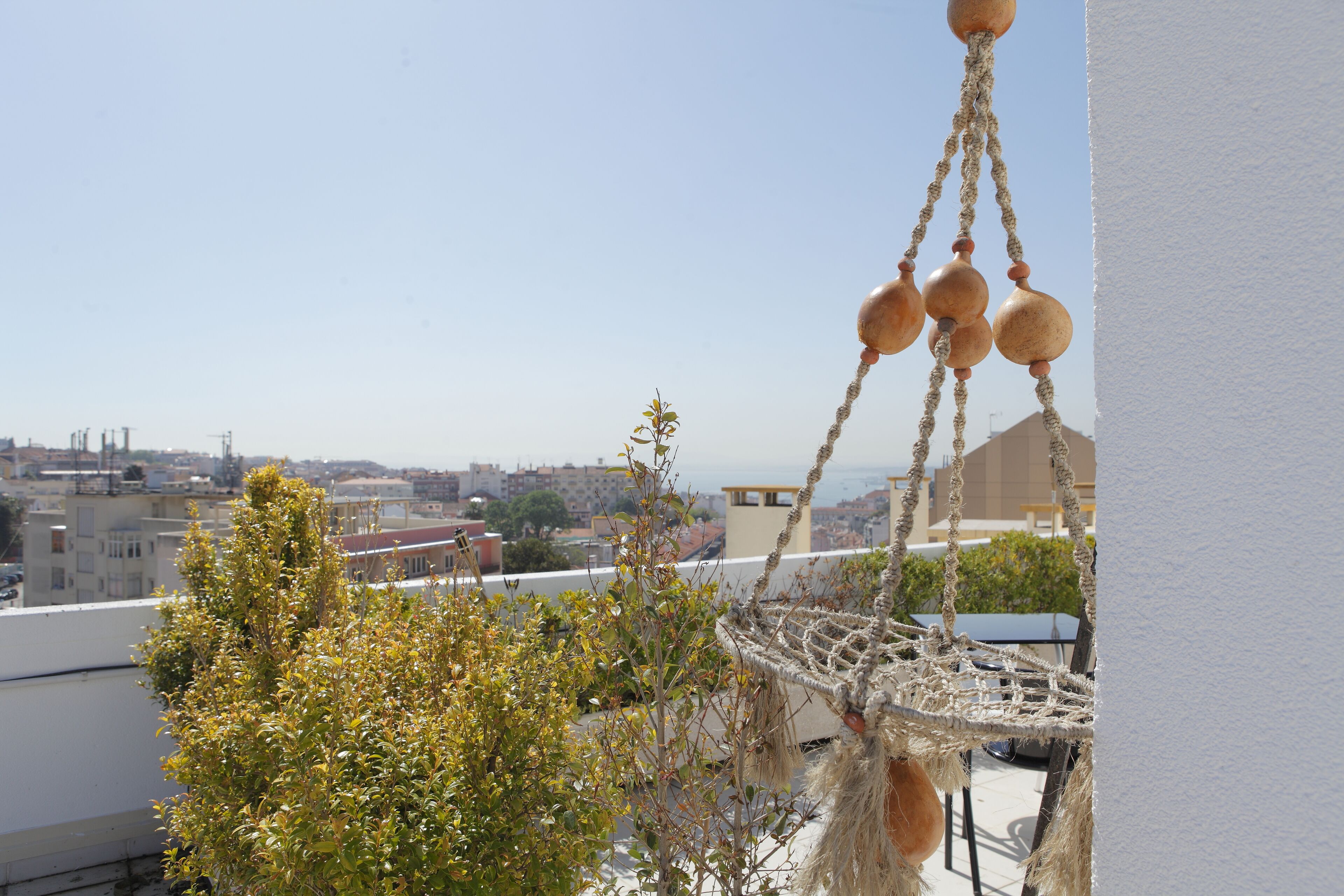 A macrame hanging ornament with a view of a cityscape in the background.