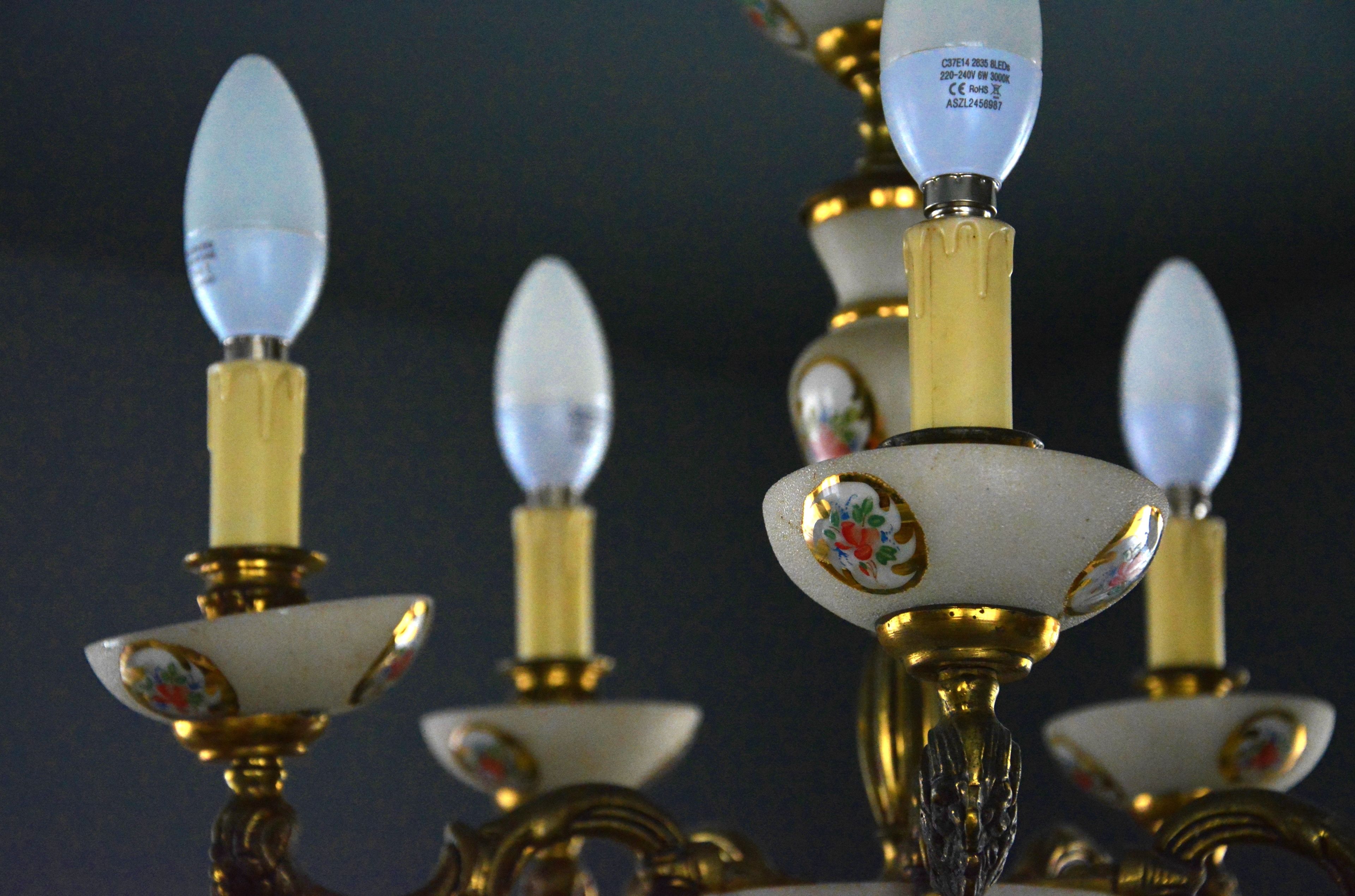 A close-up of ornate candle holders with intricate designs and a label indicating a voltage rating.