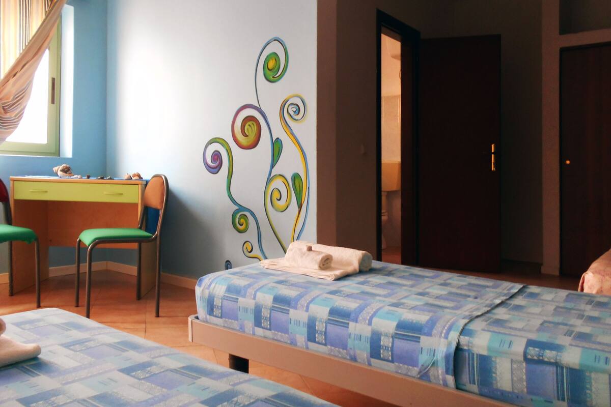 Un dormitorio con dos camas, un escritorio y una silla.