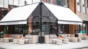 An outdoor seating area with wicker furniture and a large umbrella.