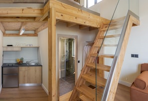A kitchen with wooden cabinets, a refrigerator, and a fruit bowl.