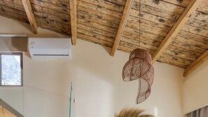 Un interno moderno con una scala in legno, un divano e uno specchio decorativo.