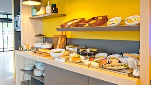 Montaje de bufé con diferentes alimentos y utensilios sobre una barra, con repisas superiores que exhiben cestas y recipientes.