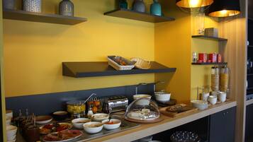 A buffet setup with various food items and serving utensils.