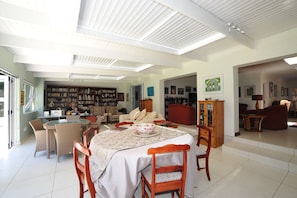 Un ampio soggiorno con zona pranzo, una biblioteca e una cucina.