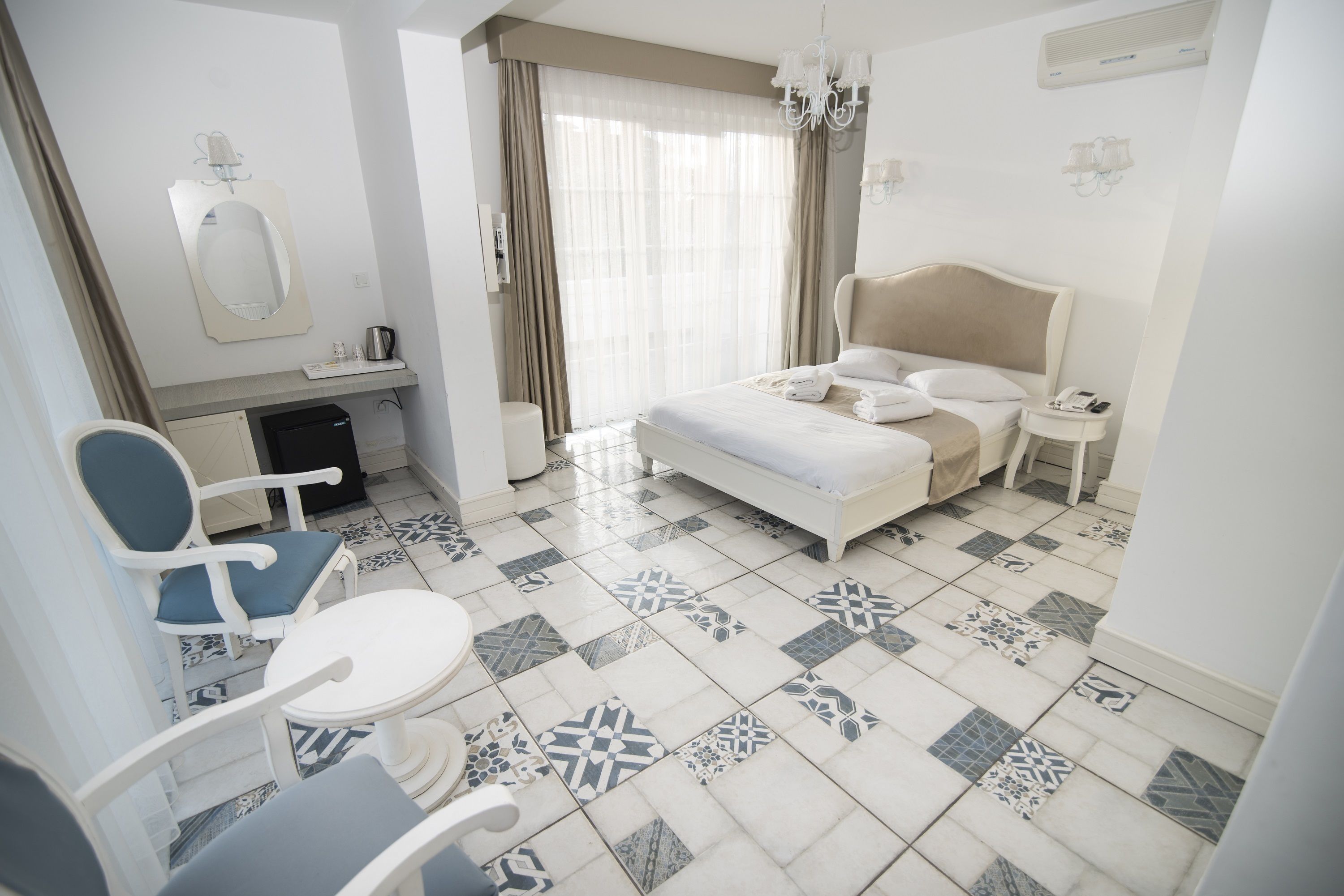 Una camera d'albergo con un letto, una scrivania, una sedia e un piccolo tavolo.