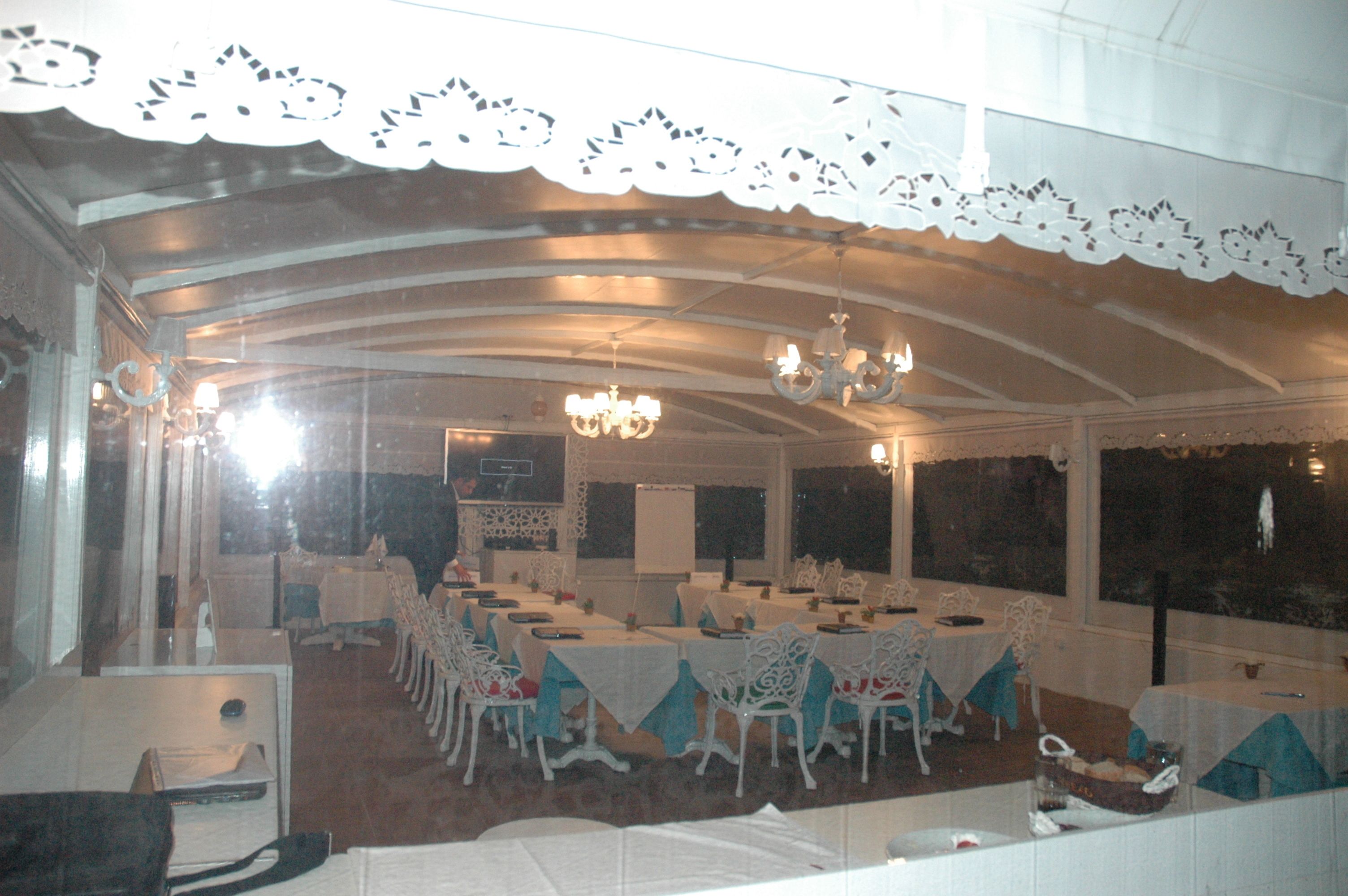 Un salón de banquetes con mesas dispuestas para comer, candelabros y un dosel de encaje.