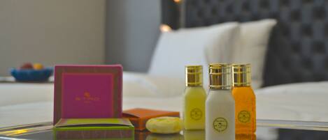 A neatly arranged table with a pink box, a green box, and three bottles with gold caps.