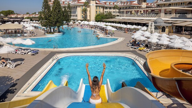 A large outdoor swimming pool area with multiple slides and lounge chairs.