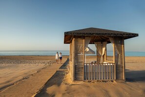 Aan een privéstrand, ligstoelen, parasols, strandlakens