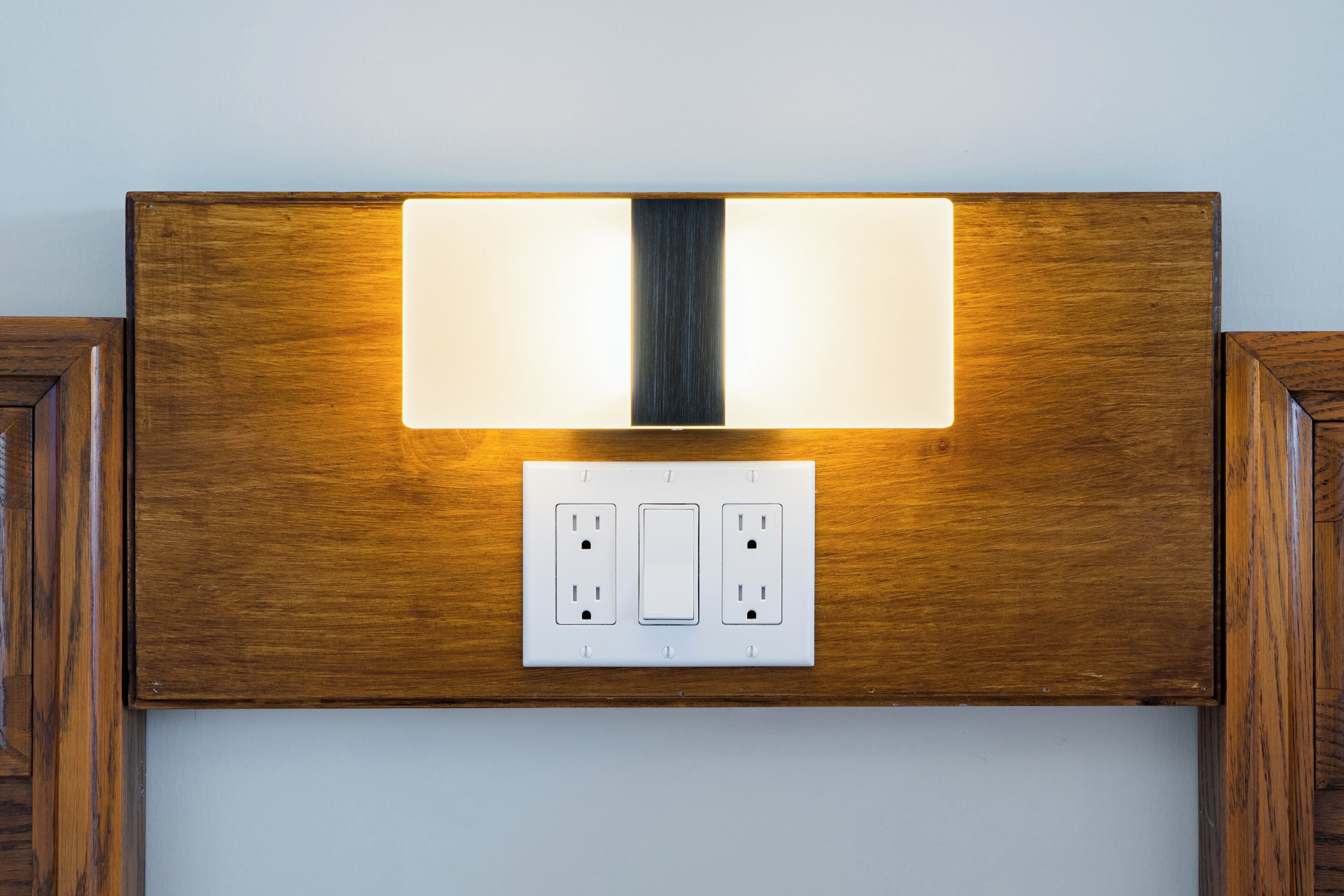 Un luminaire mural doté d’un interrupteur et de deux prises électriques.