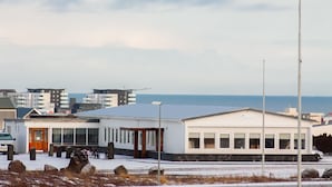 A building with a flat roof, large windows, and a sign that reads "Café & Restaurant".