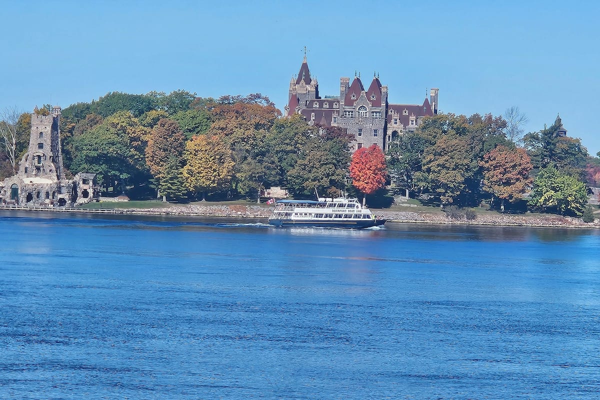 A historic building with a prominent tower and a boat docked in the foreground.
