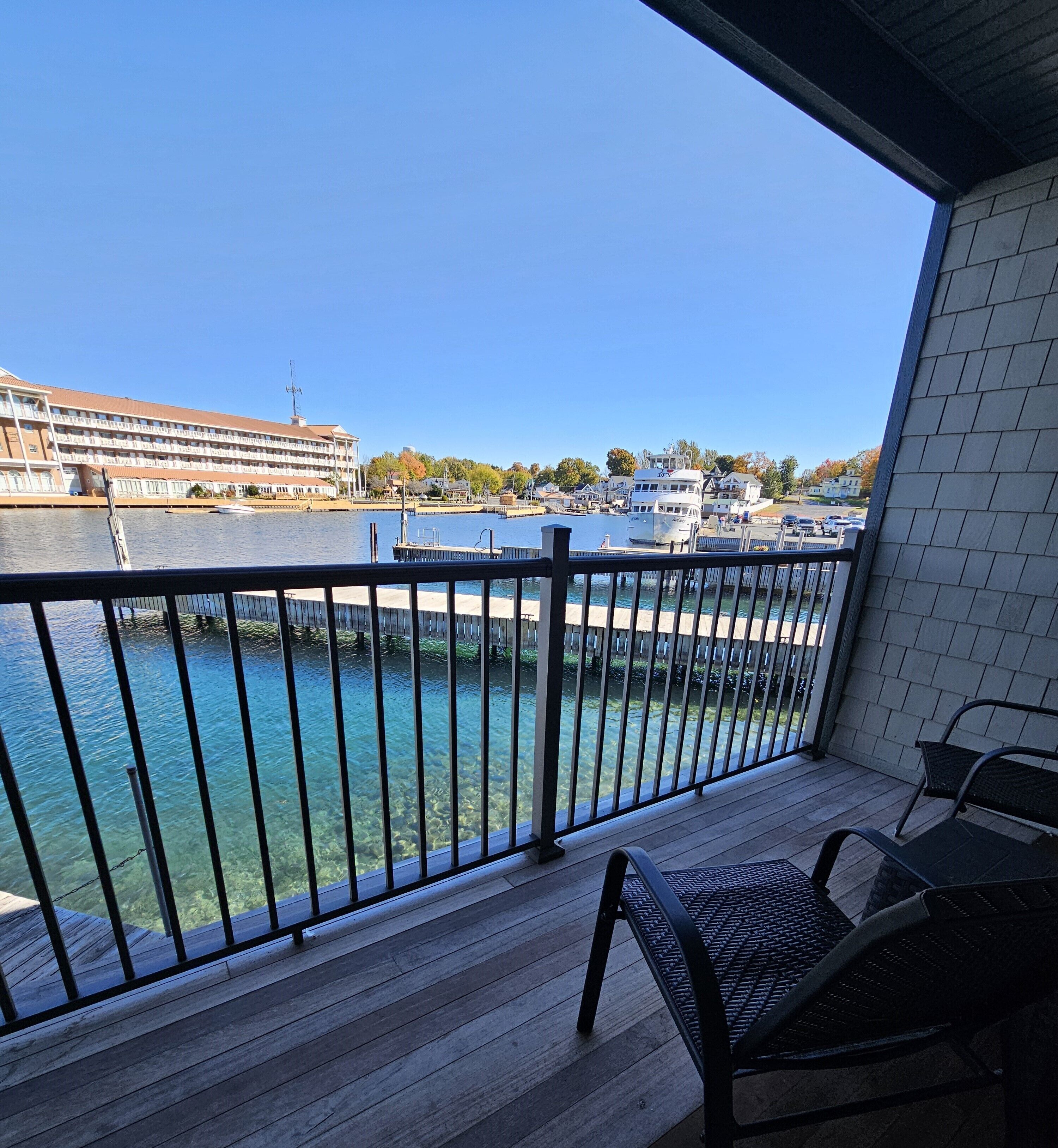 A balcony with a view of a marina, including boats and a hotel in the background.
