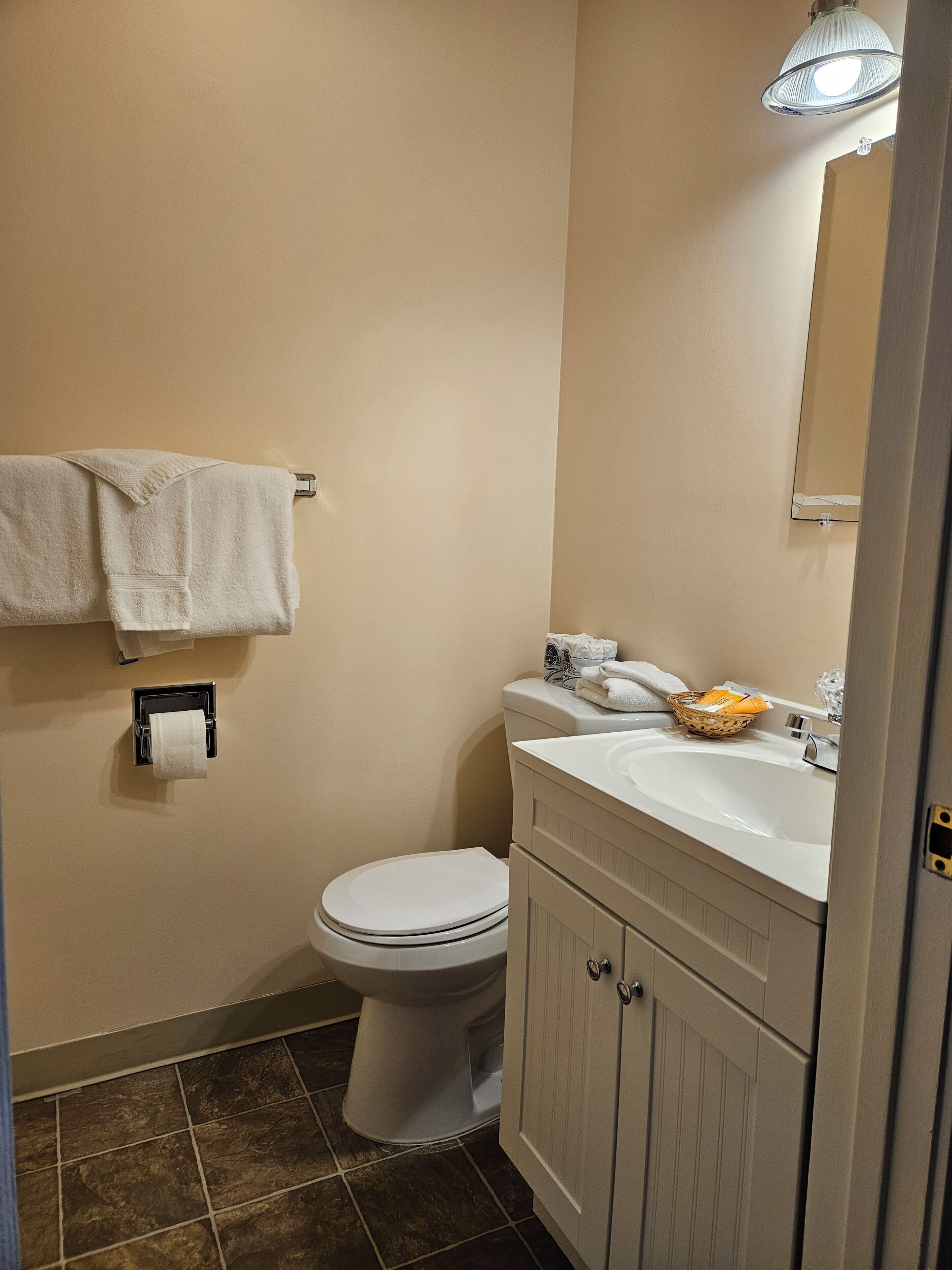 Une salle de bain équipée de toilettes, d’un lavabo et d’un porte-serviettes.