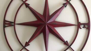 A circular metal wall decoration with compass directions.