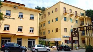 A multi-story building with a yellow facade, several windows, and a sign that reads "San Martino."