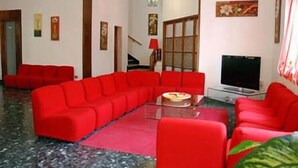 A living room with red sofas, a TV, and a staircase.