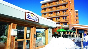 A hotel with a sign reading "Berangere" and a restaurant named "Restaurant Bar Berangere" in front. - La Bérangère (Chamrousse)