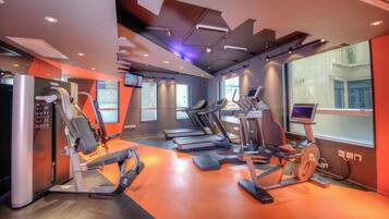 A modern gym with treadmills, ellipticals, and weight machines.