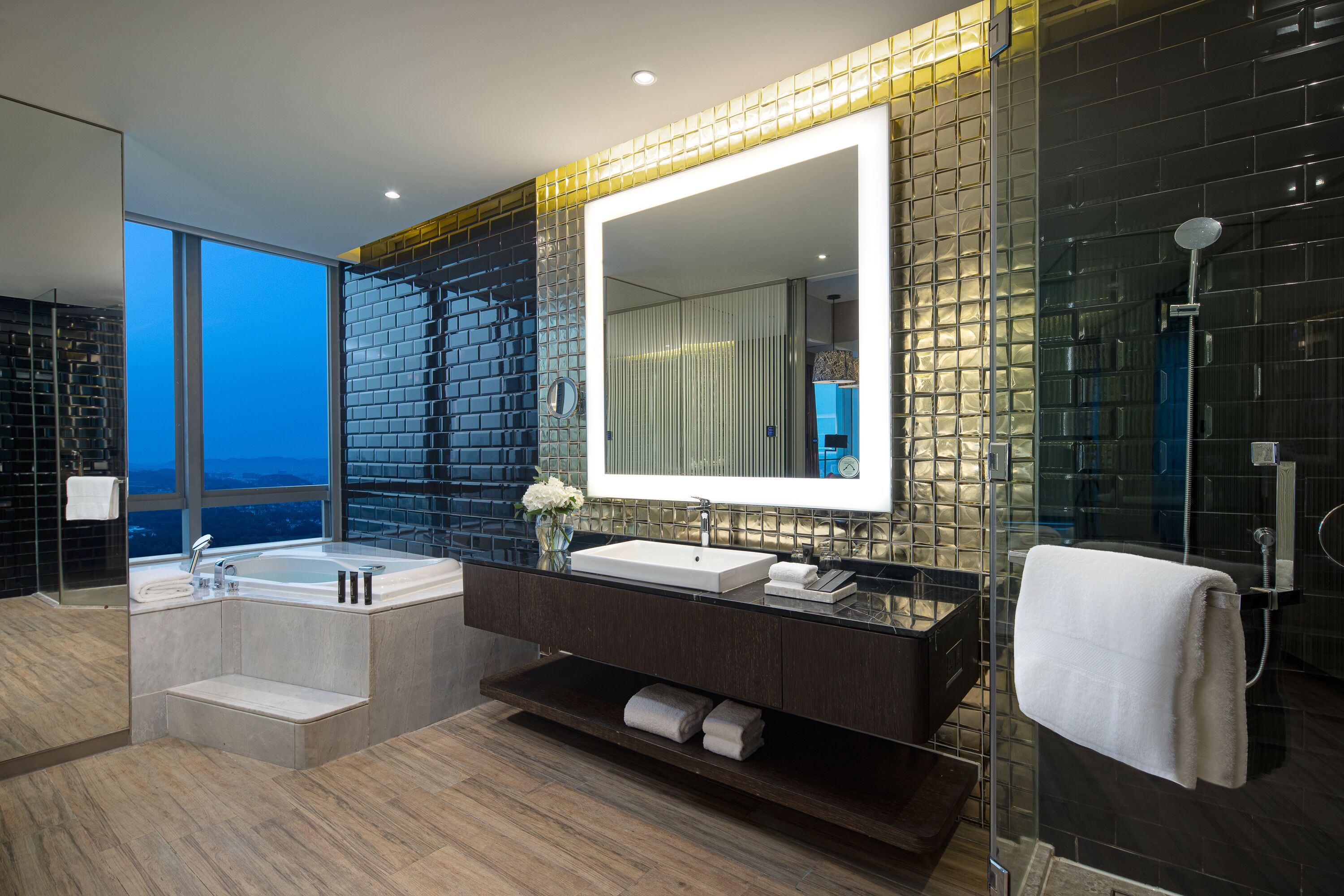 Un baño moderno con un espejo grande, lavamanos dobles y una bañera.