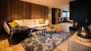 A modern living room with a sofa, coffee table, and fireplace. - Wellness Hasselt Bed & Breakfast (Hasselt)