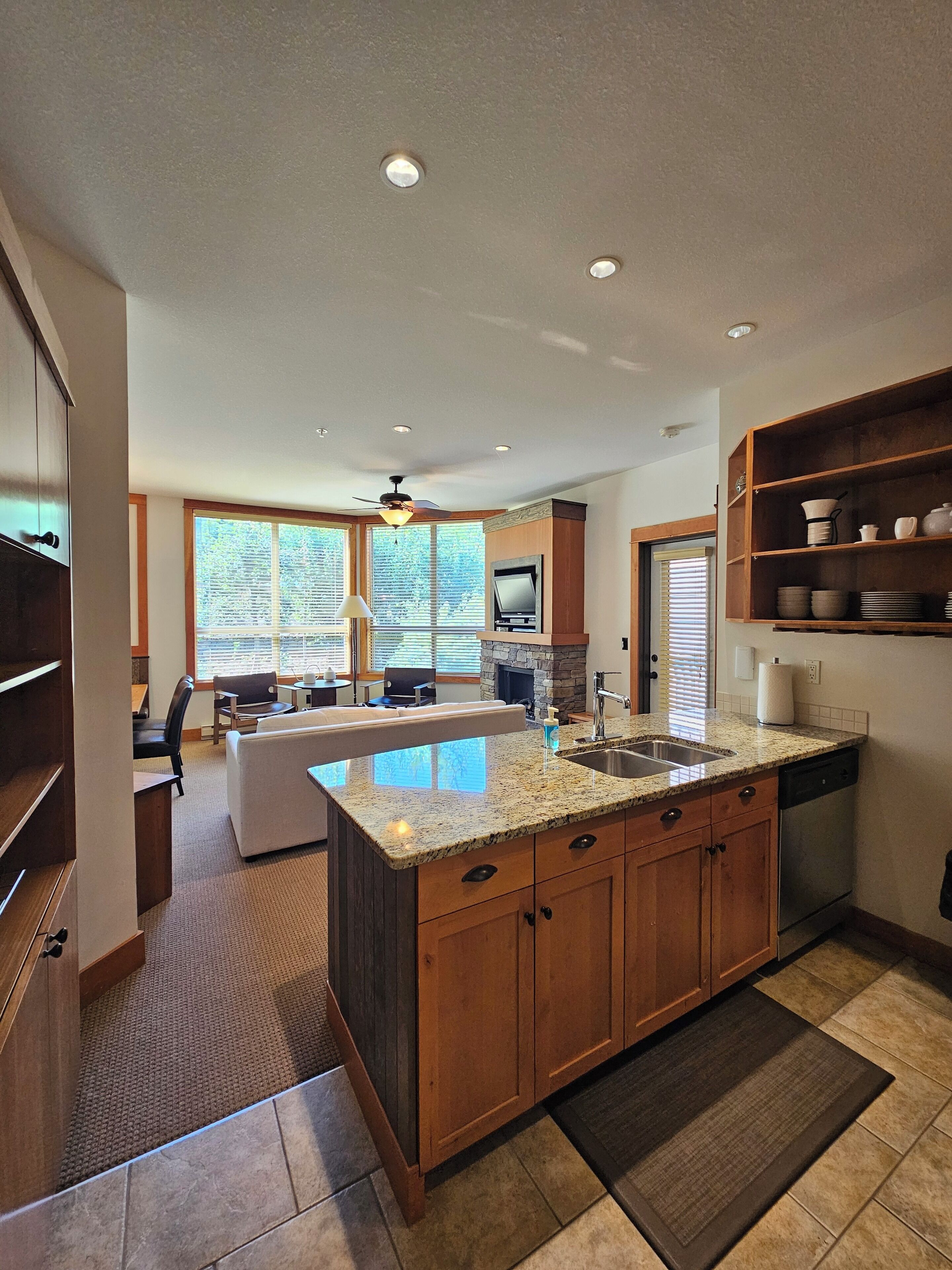 A modern kitchen with granite countertops, wooden cabinets, and a large island.