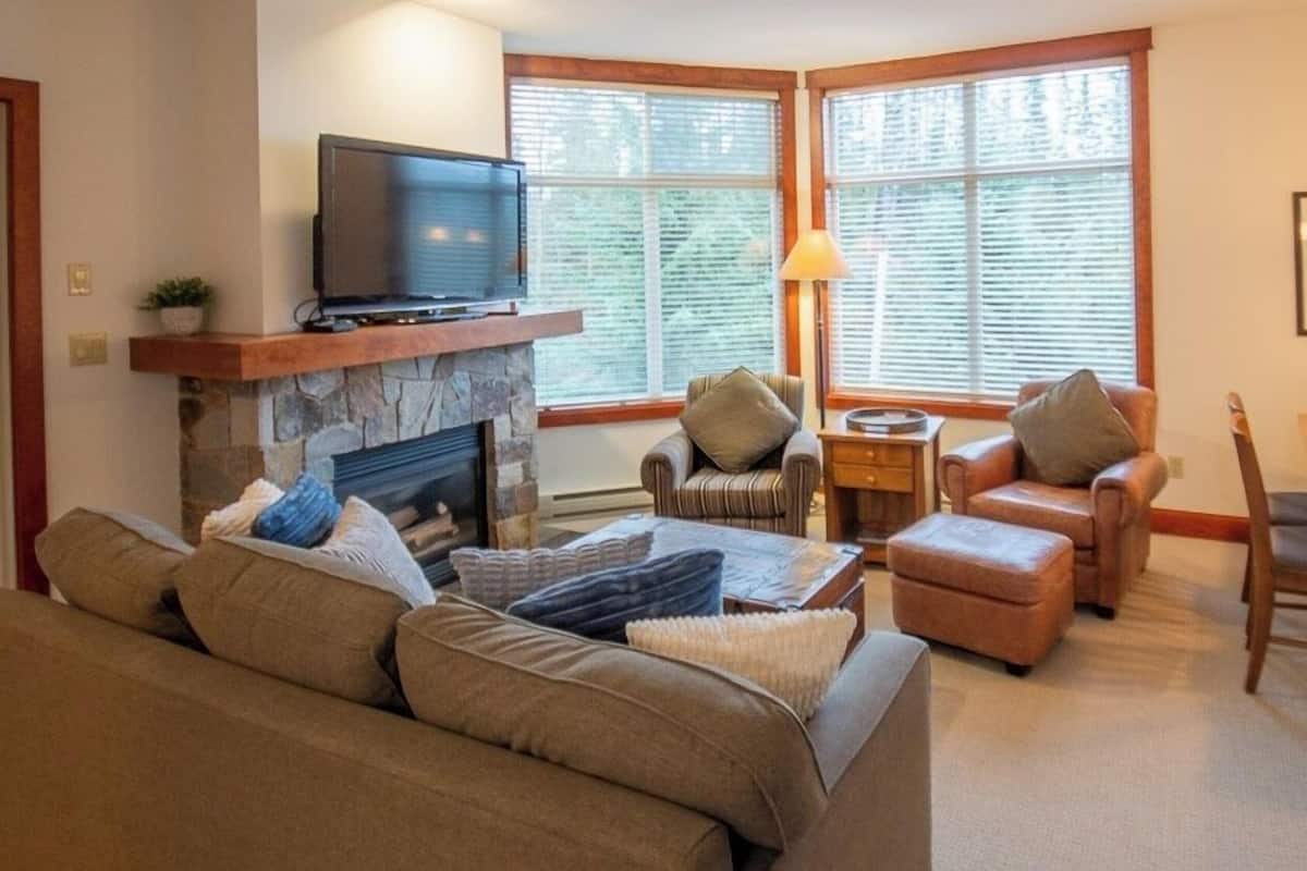 A cozy living room with a fireplace, a television, and comfortable seating.