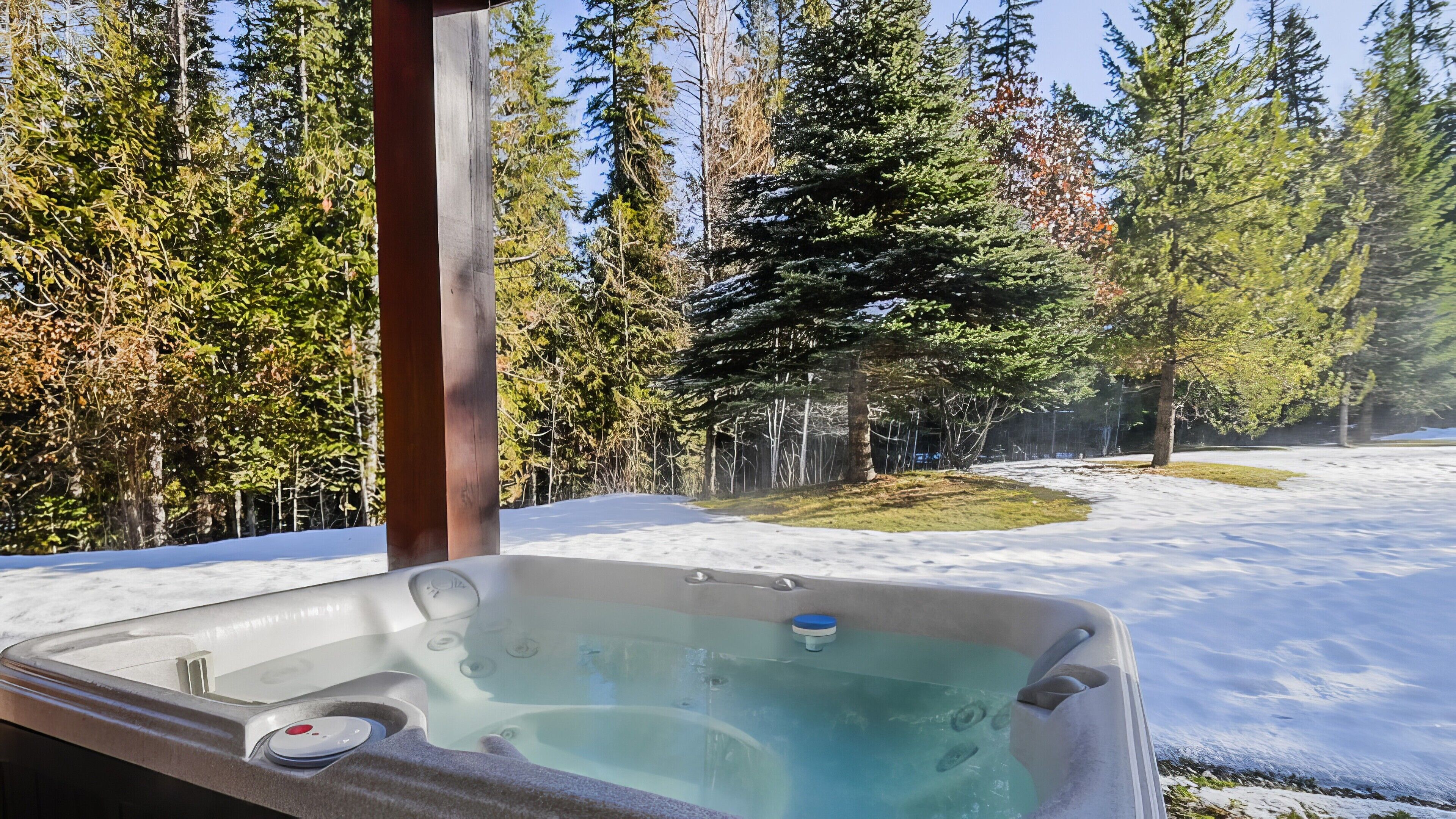 A hot tub in a snowy outdoor setting with a forest backdrop.