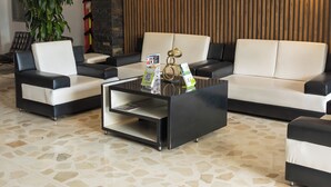 Una sala moderna con un sofá modular, una mesa de centro y una planta en maceta.
