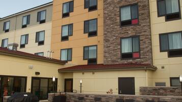 A hotel with a stone facade, outdoor seating area, and a fire pit.