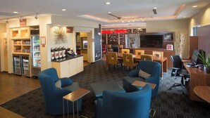 Een hotel lobby met zithoeken, een kitchenette en een bar.