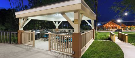 An outdoor patio with a grill area, seating, and a covered walkway.