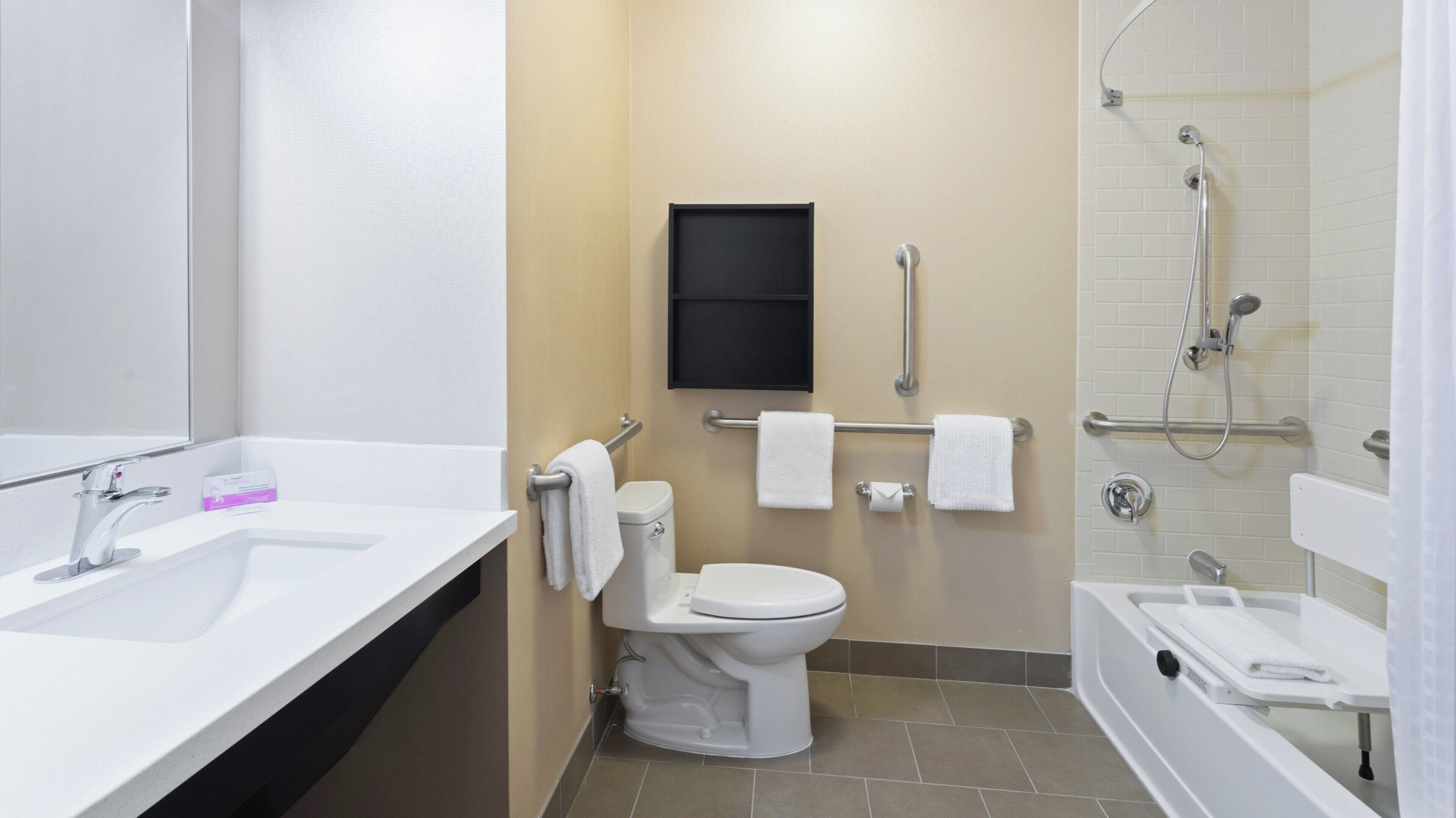 Une salle de bain moderne équipée d’un lavabo, de toilettes et d’une zone douche.