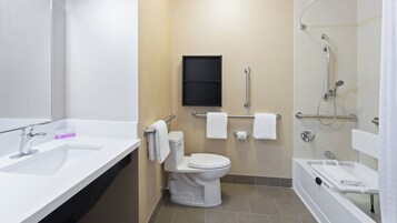 Un baño moderno con lavamanos, inodoro y zona de ducha.