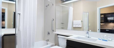 Et stilfuldt badeværelse med badekar, toilet og et stort spejl.
