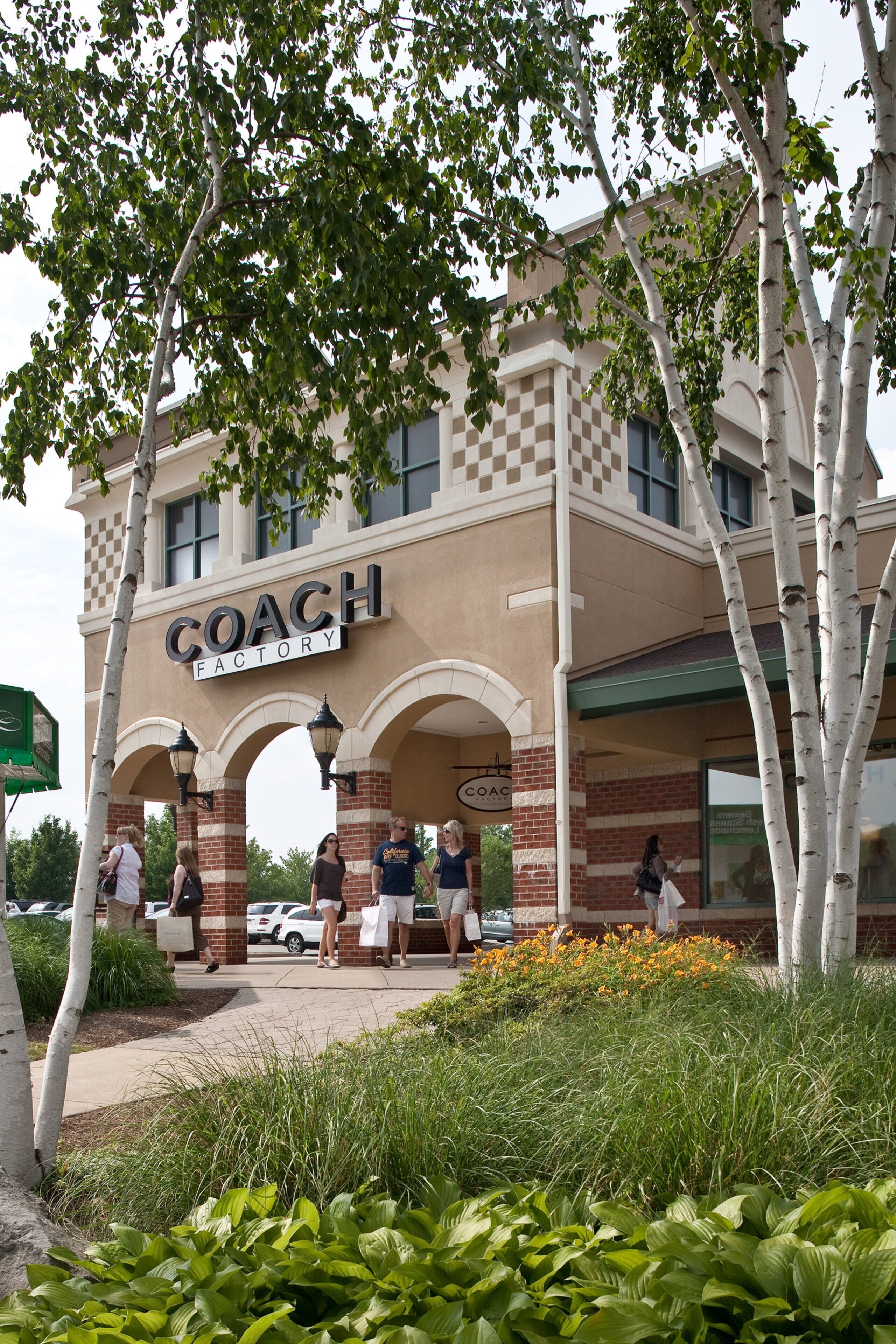 A building with a sign reading 'COACH FACTORY' and a covered entrance with arches.