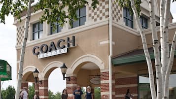 A building with a sign reading 'COACH FACTORY' and a covered entrance with arches.